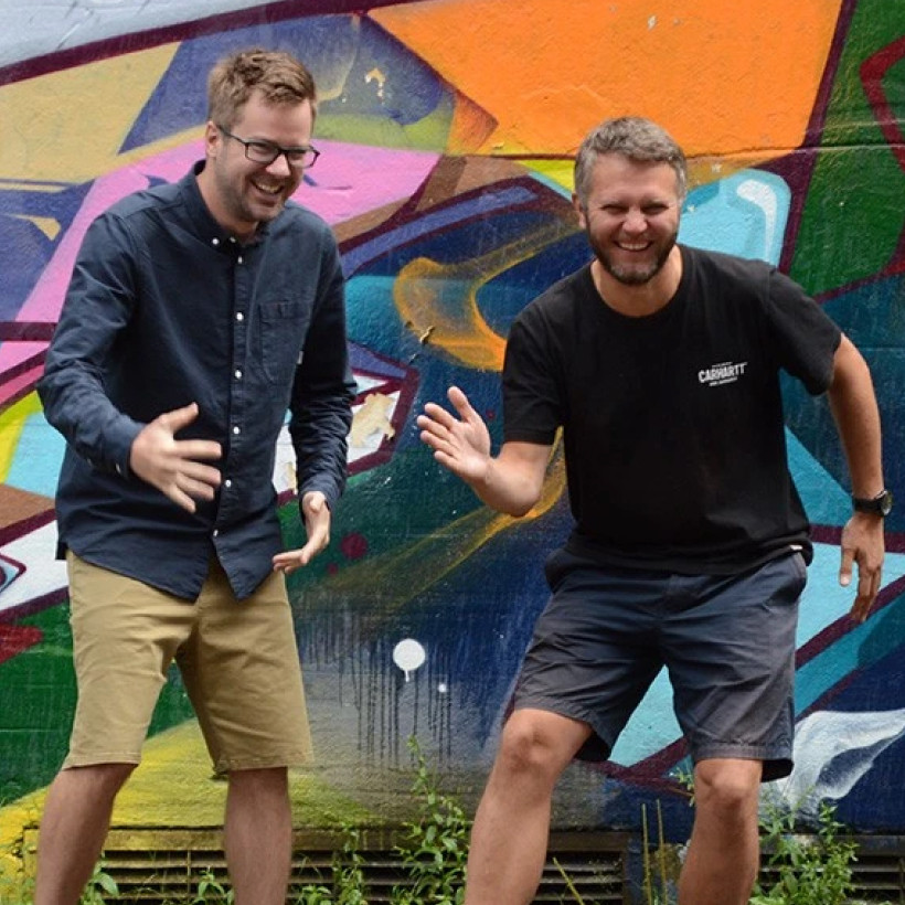 Kevin and Kristian from DUX next to a graffiti wall